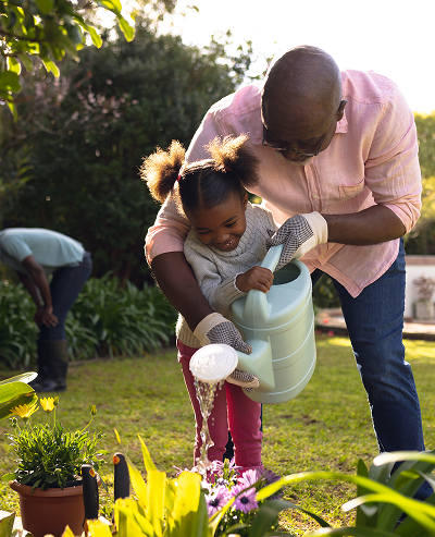 grandfather and child watering a garden
